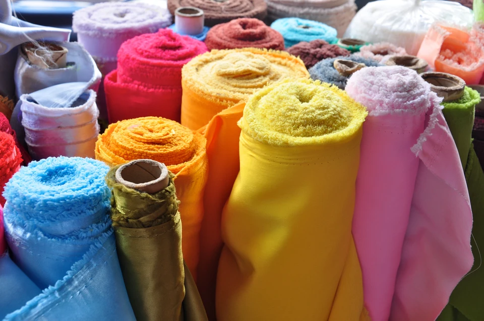 Marché textile extérieur avec étals de tissus colorés