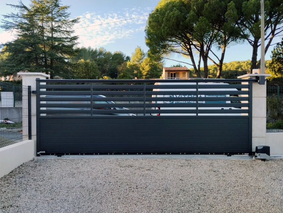 Portail coulissant moderne en aluminium anthracite avec lames horizontales ajourées dans la partie haute et panneau plein en bas