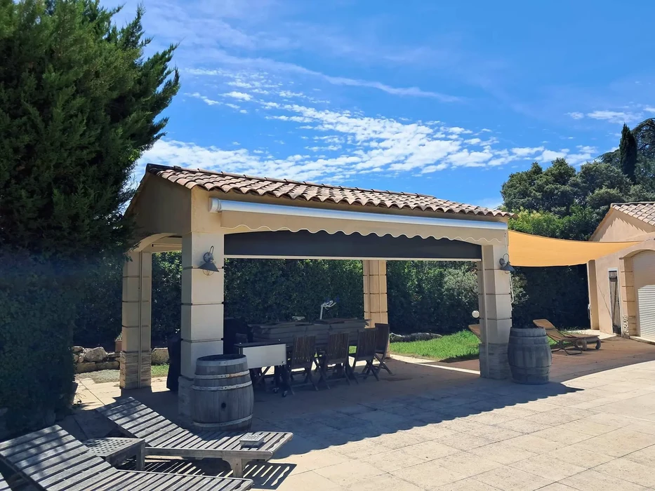 Terrasse extérieure couverte avec pergola en béton et toiture tuiles terre cuite