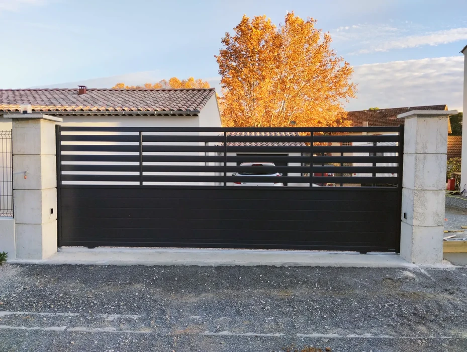 Façade extérieure d'un bâtiment avec deux portes de garage métalliques blanches à lames horizontales, l'une fermée et l'autre partiellement ouverte