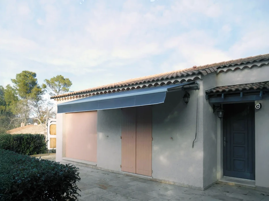 Maison moderne avec grande baie vitrée coulissante ouverte sur jardin verdoyant