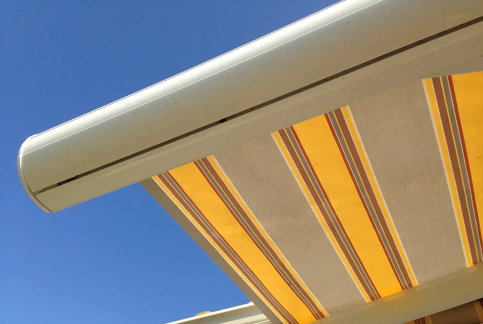 Jeune artisan souriant dans son atelier de menuiserie, portant tablier de cuir et ceinture &agrave; outils garnie