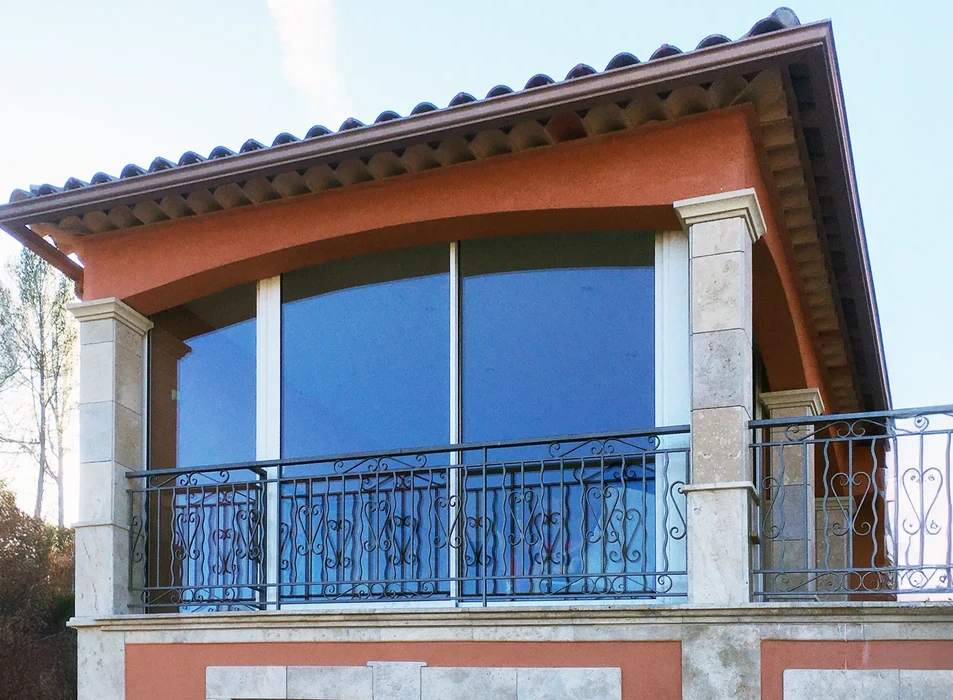 Façade extérieure d'habitation avec porte-fenêtre coulissante à deux vantaux vitrés ouverte sur chambre