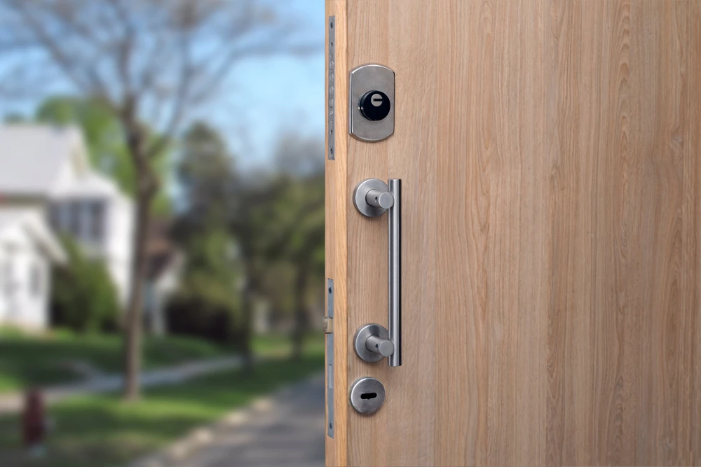 Extérieur résidentiel avec porte d'entrée en bois clair ouverte