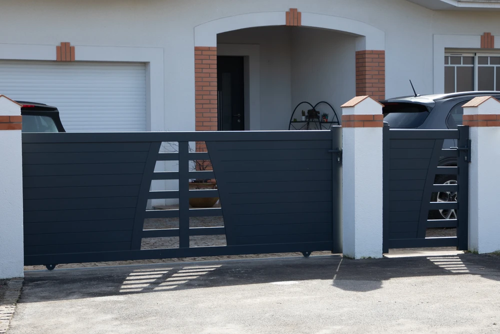 Entrée de maison moderne avec portail coulissant anthracite à lames horizontales et inserts rectangulaires décoratifs